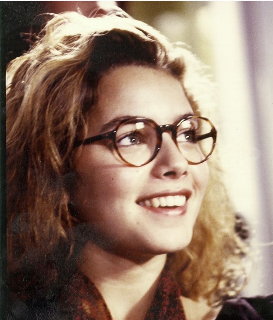 Mili Avital smiling in round glasses, film still